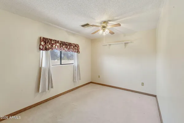 an empty room with windows and fan