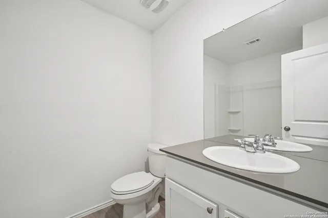 a bathroom with a sink toilet and a mirror