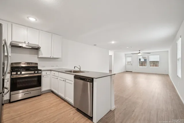 a kitchen with granite countertop a stove and a wooden floors
