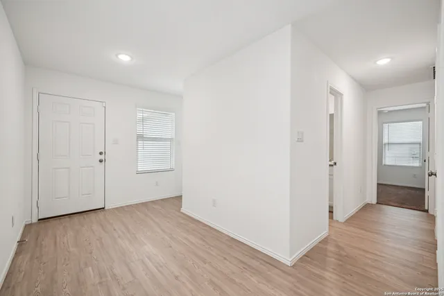 a view of an empty room with wooden floor and closet
