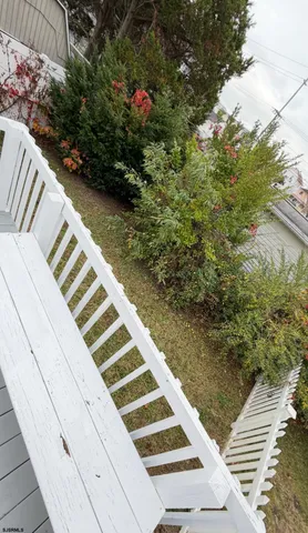 a balcony with couple of flower plants and wooden fence