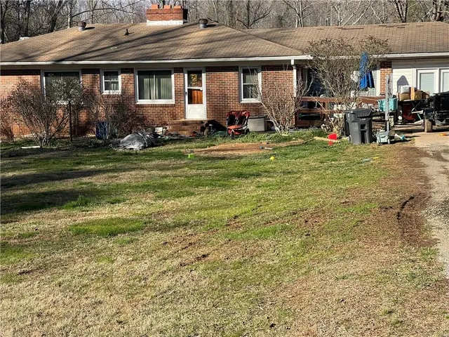 a view of a house with a yard and sitting area