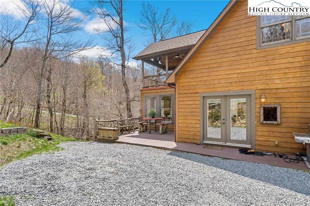 140 Spruce Hollow Road Beech Mountain, NC 28604 - Photo 32 of 50 a backyard of a house with barbeque oven table and chairs