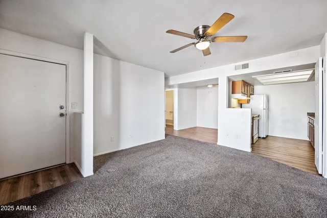 a view of a livingroom with a ceiling fan and wooden floor