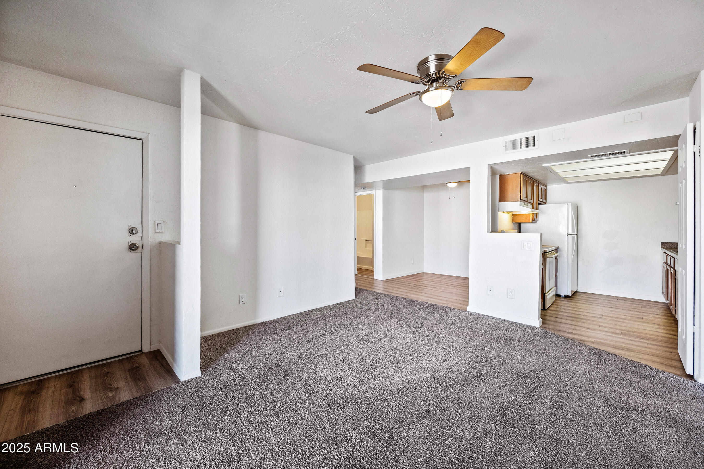 16602 North 25th Street, Unit 212 Phoenix, AZ 85032 - Photo 6 of 16 a view of a livingroom with a ceiling fan and wooden floor