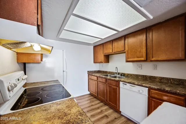 a kitchen with stainless steel appliances granite countertop a sink stove and cabinets