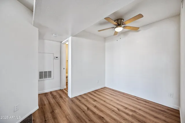 a view of empty room with wooden floor