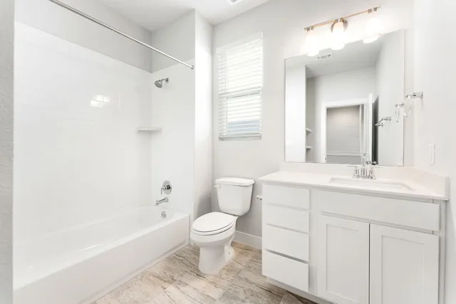 a view of an empty room with closet and a window