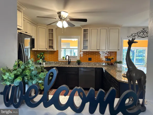 a kitchen with granite countertop a sink a stove and a window