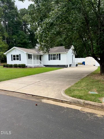 a front view of a house with a yard and trees