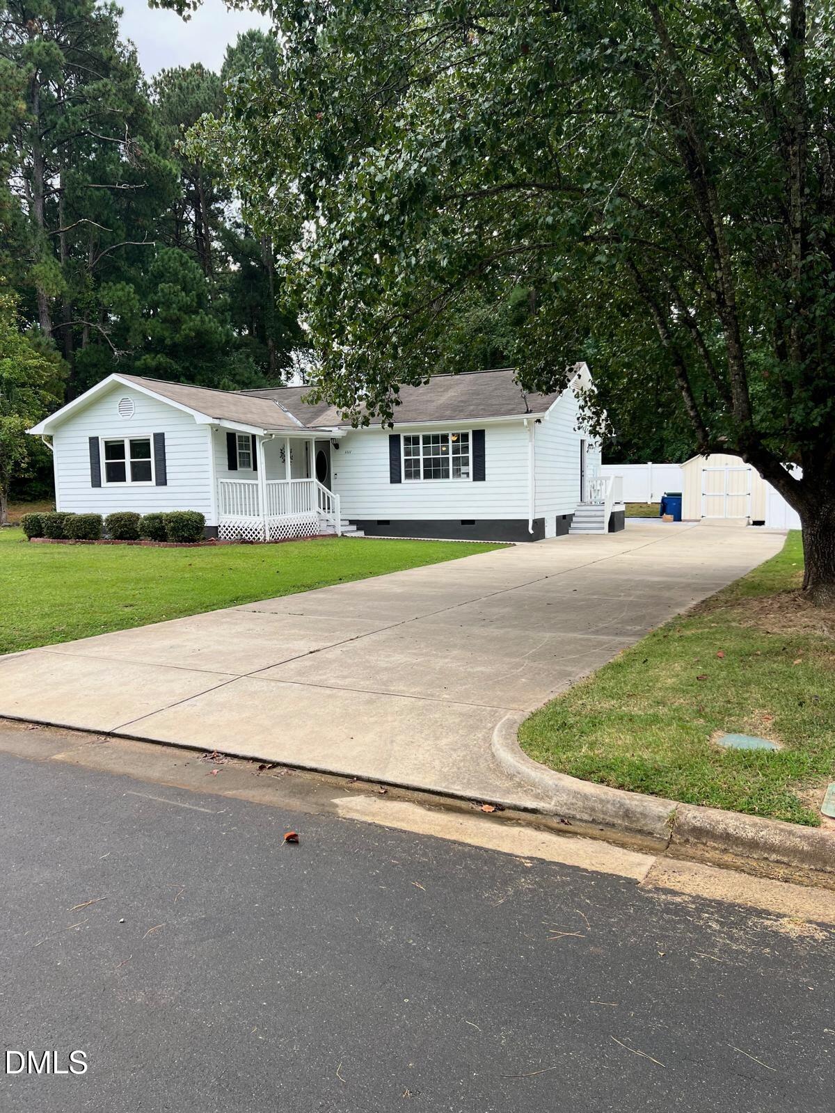 a front view of a house with a yard and trees