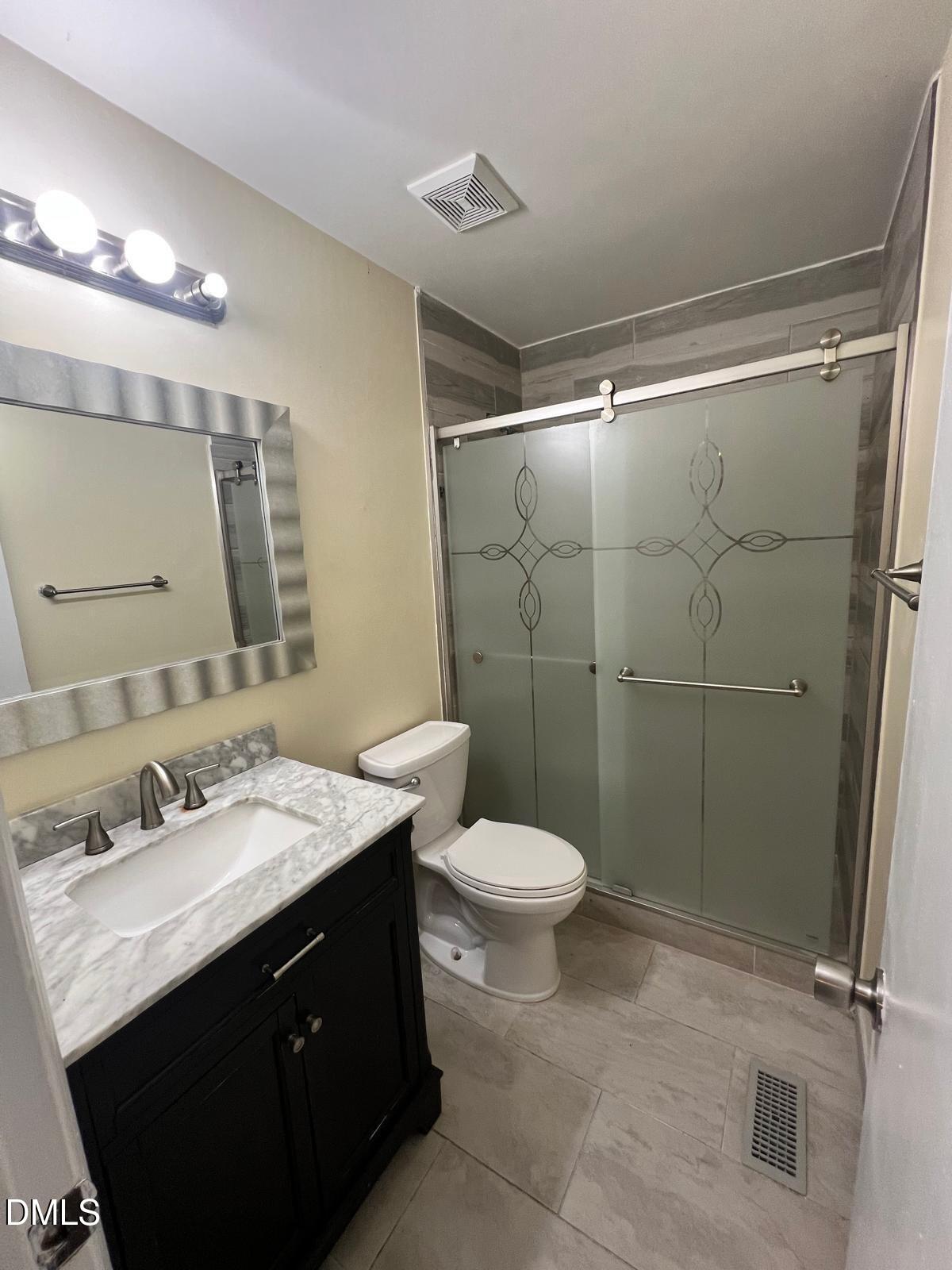 1111 Penzance Avenue Durham, NC 27704 - Photo 15 of 18 a bathroom with a sink a toilet a mirror and shower