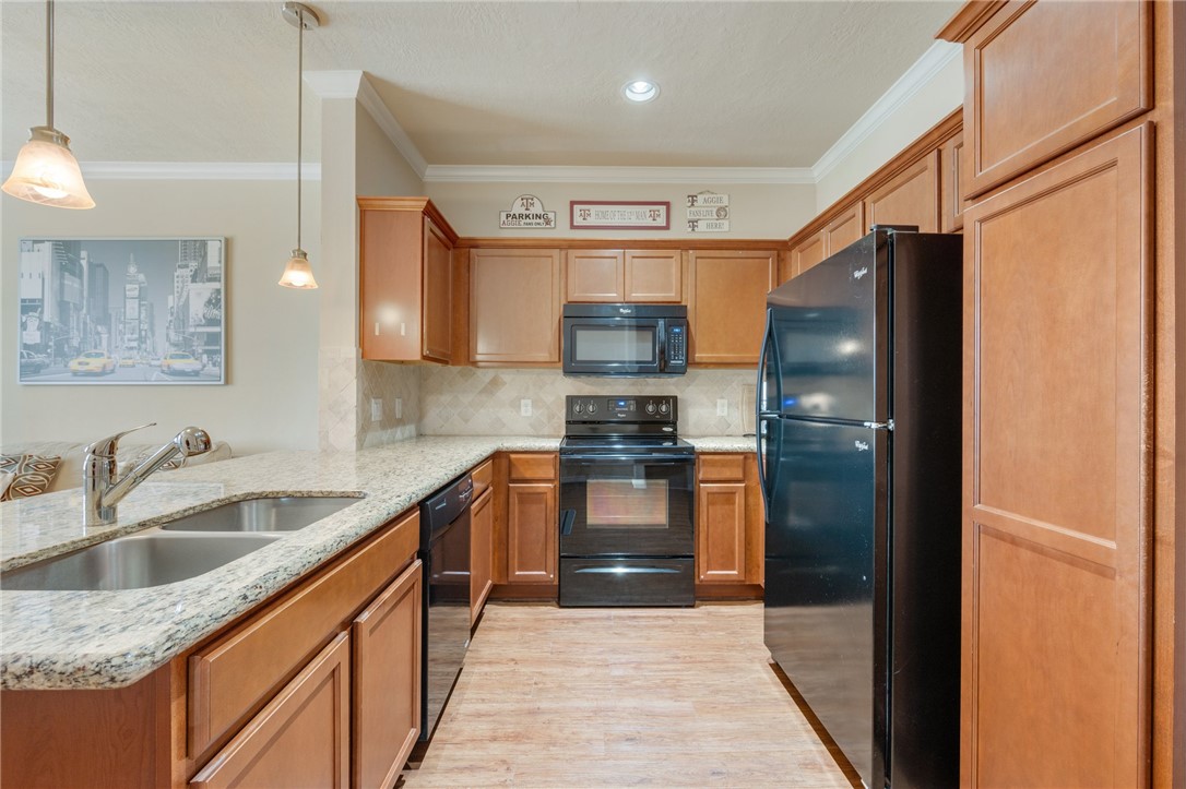 1198 Jones-Butler Road, Unit 3110 College Station, TX 77840 - Photo 5 of 16 a kitchen with stainless steel appliances granite countertop a refrigerator and a sink