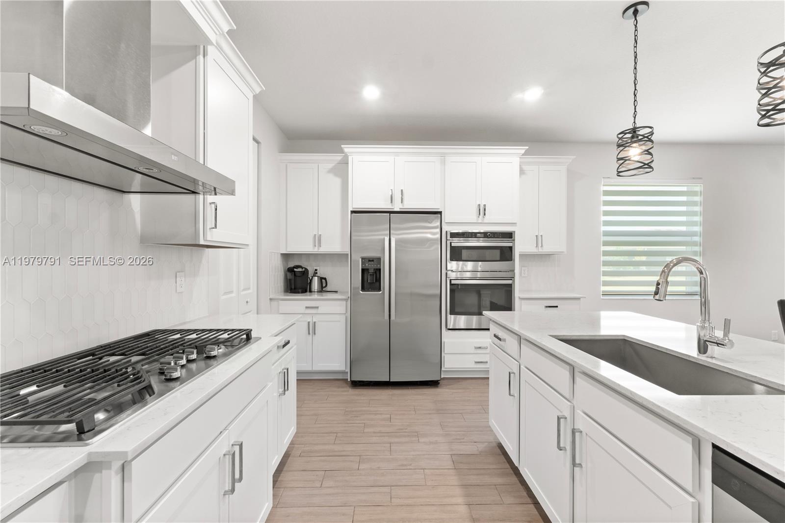 1162 Haywagon Trail Loxahatchee, FL 33470 - Photo 12 of 50 a kitchen with a sink stainless steel appliances cabinets and a window