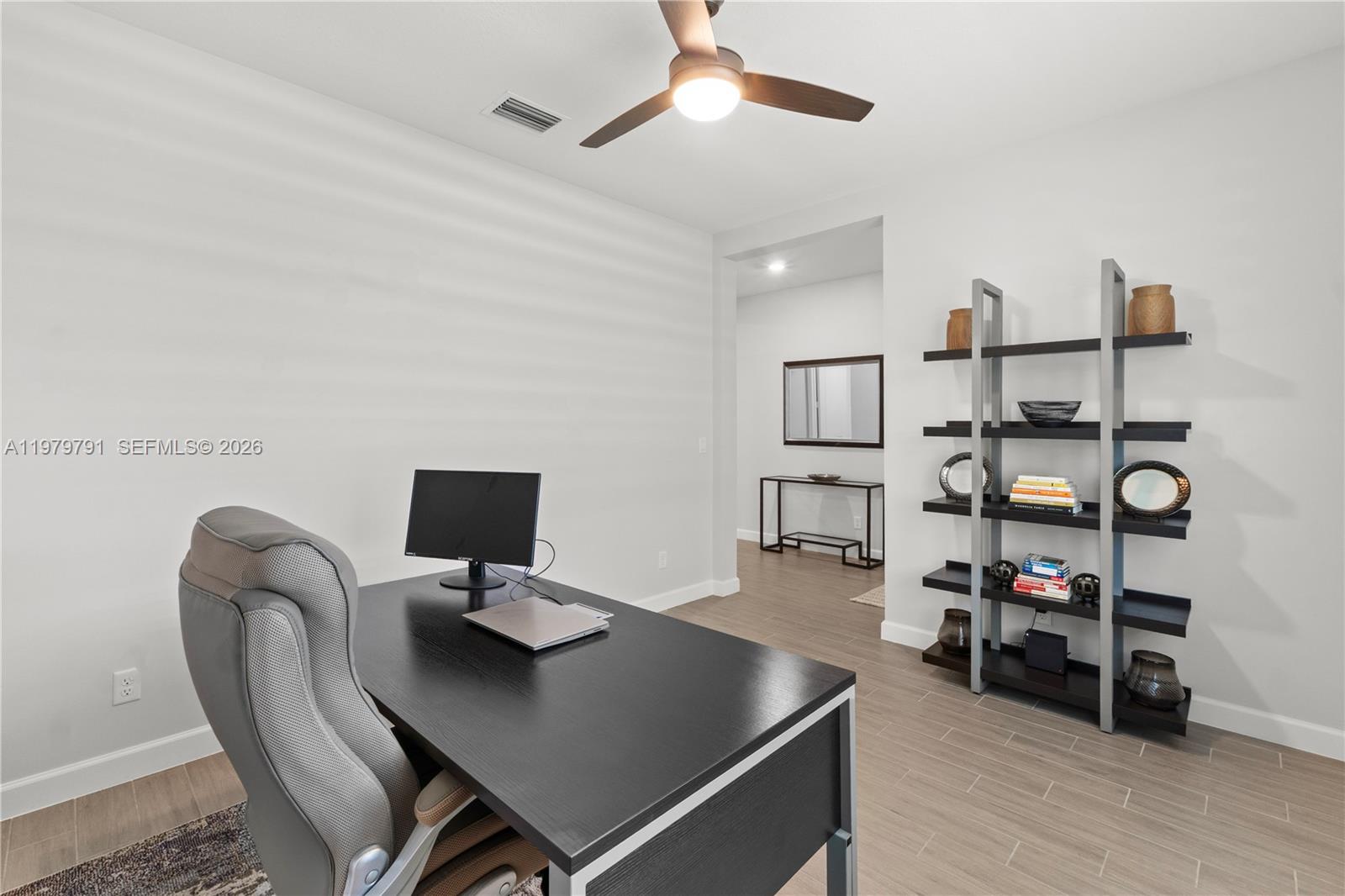 1162 Haywagon Trail Loxahatchee, FL 33470 - Photo 19 of 50 a view of a workspace with furniture and wooden floor