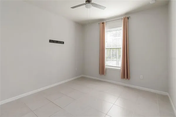 an empty room with closet and a ceiling fan
