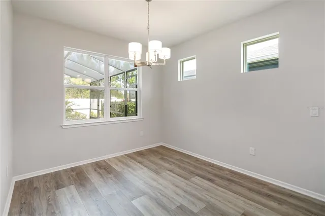 a view of empty room with wooden floor and stove