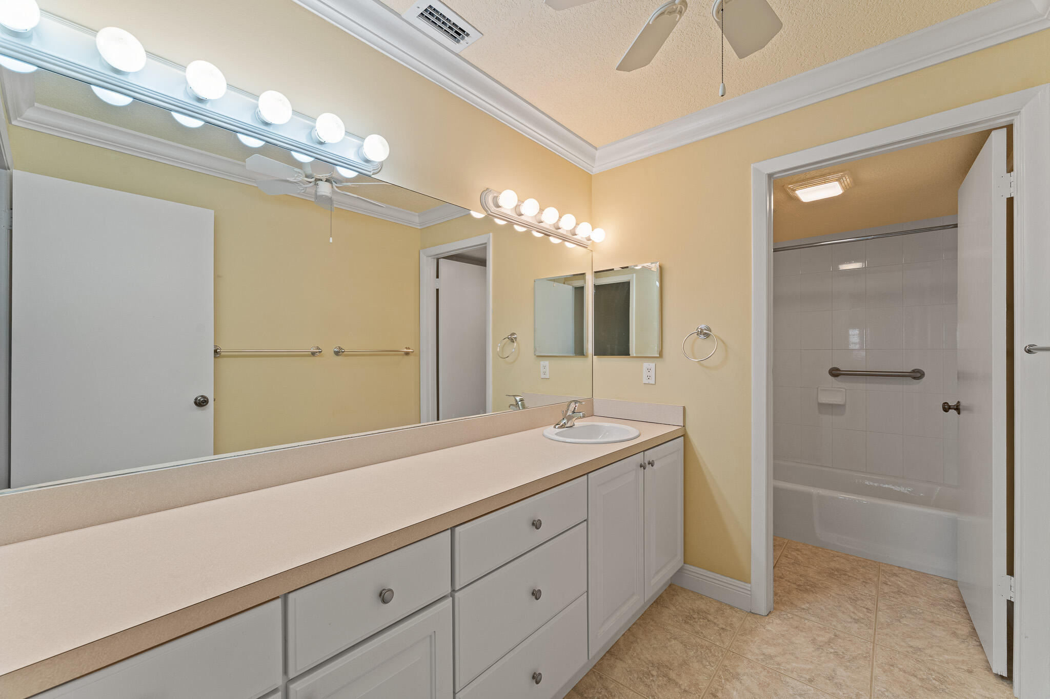 10 Northeast Plantation Road, Unit 305 Jensen Beach, FL 34957 - Photo 33 of 48 a spacious bathroom with a granite countertop sink a mirror and a shower