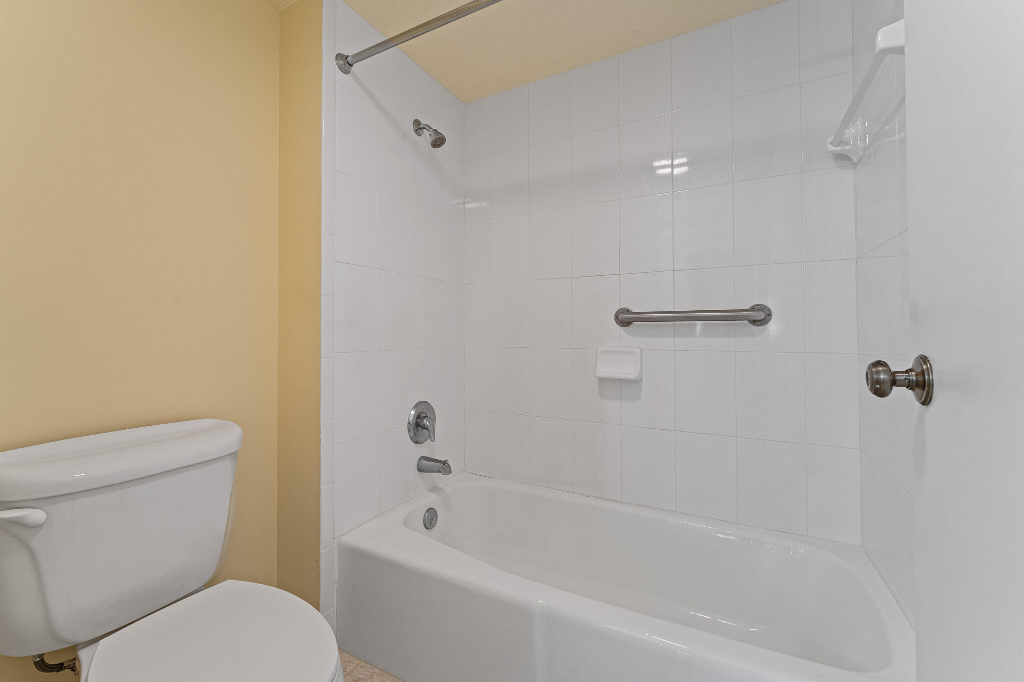 10 Northeast Plantation Road, Unit 305 Jensen Beach, FL 34957 - Photo 34 of 48 a white toilet sitting next to a bath tub