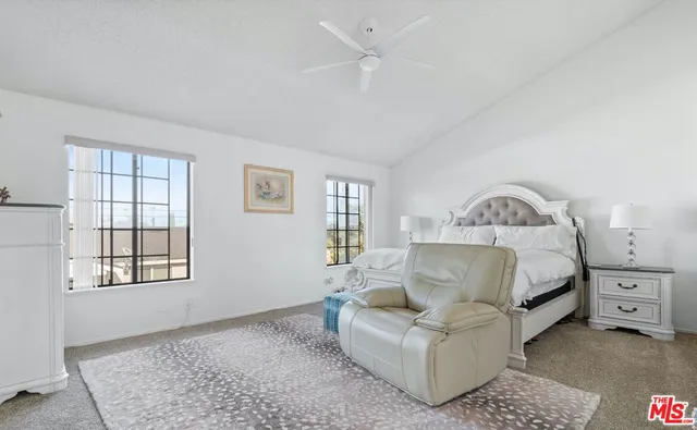 a large bathroom with a tub a sink and glass windows