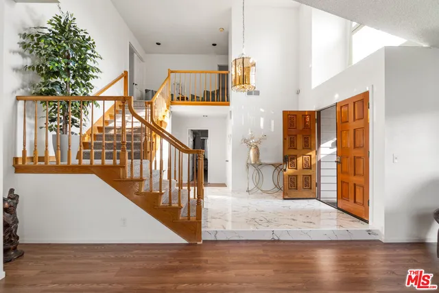 a view of a hallway with wooden floor and staircase