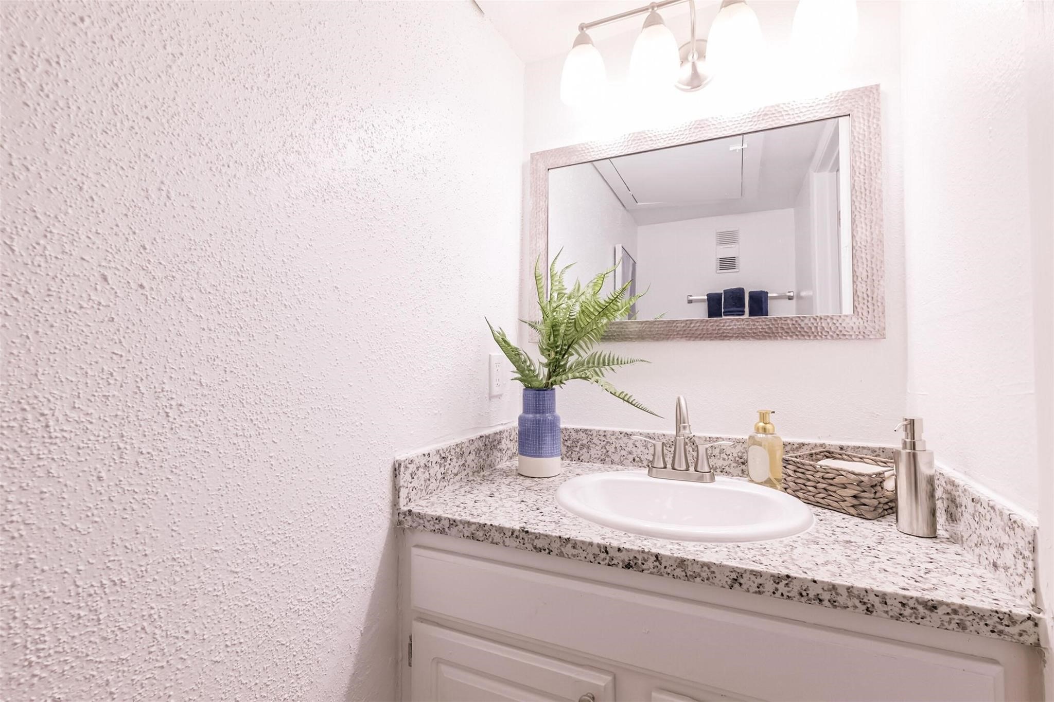 8162 Richmond Avenue, Unit 506 Houston, TX 77063 - Photo 10 of 33 a bathroom with a granite countertop sink and a mirror