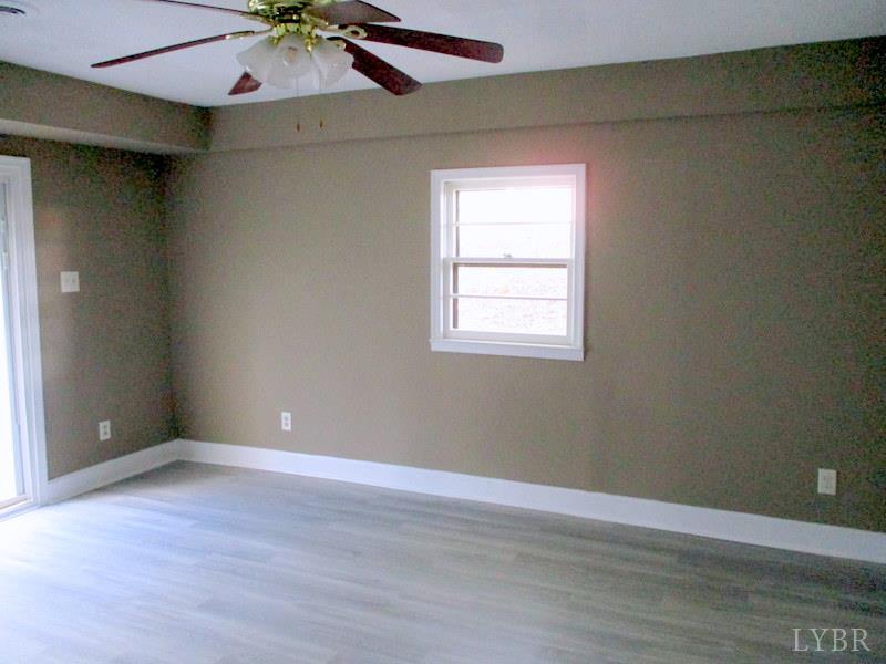 102 Ridgeview Road Hurt, VA 24563 - Photo 31 of 41 an empty room with a chandelier fan and wooden floor