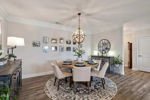 a kitchen with stainless steel appliances kitchen island granite countertop a table chairs refrigerator and microwave