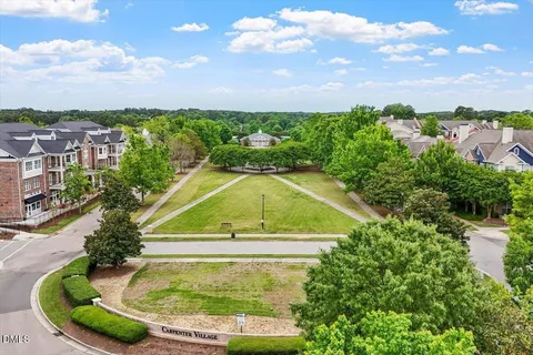 an aerial view of residential houses with outdoor space and lake view