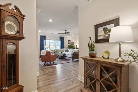 a living room with furniture kitchen view and a chandelier
