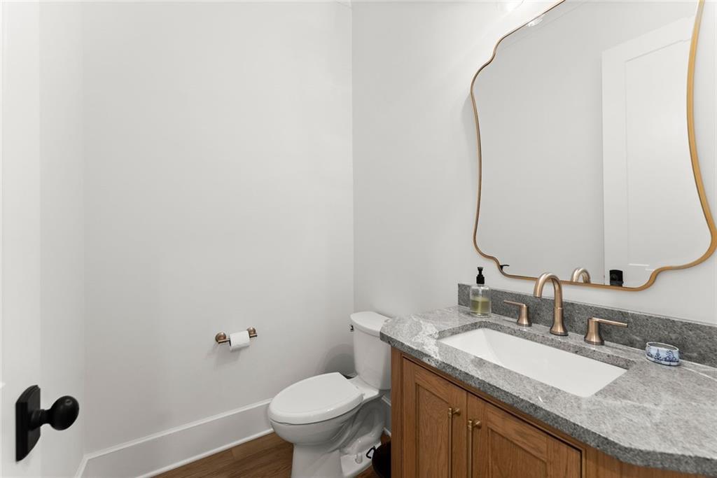 3116 Winding Lake Court Gainesville, GA 30504 - Photo 24 of 94 a bathroom with a granite countertop sink a toilet and a mirror