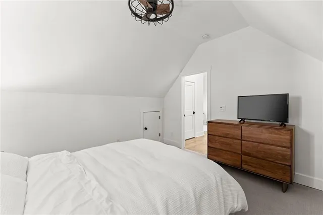 a view of a white house with a small yard and palm trees