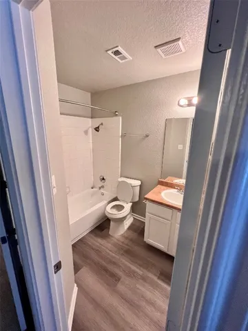 a bathroom with a sink a toilet a tub and shower