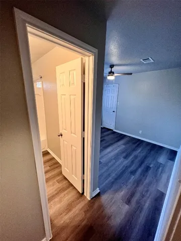 a view of a hallway with wooden floor and a window