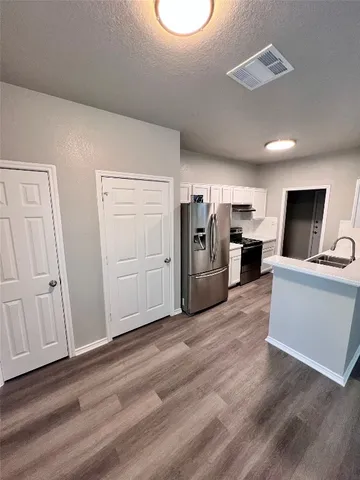a kitchen with stainless steel appliances a refrigerator and a stove top oven