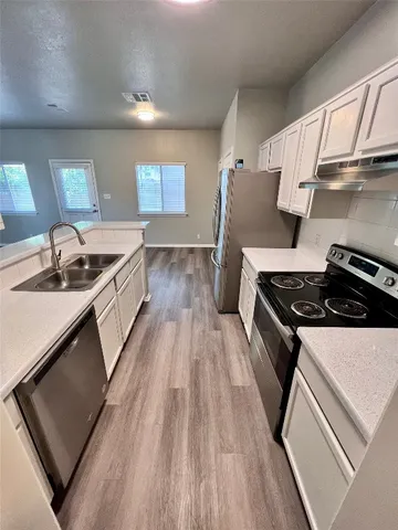 a kitchen with granite countertop a sink stove and cabinets