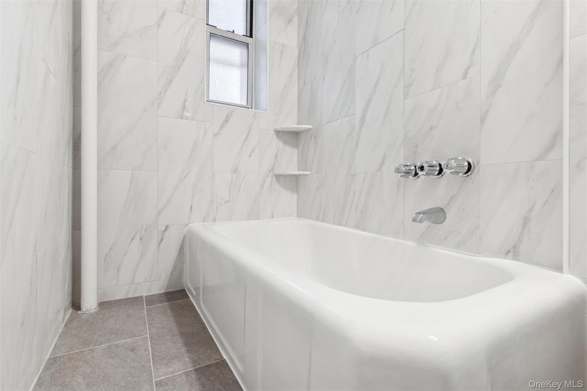 67-12 Yellowstone Boulevard, Unit B16 Queens, NY 11375 - Photo 11 of 15 Bathroom with tile walls and tile patterned flooring