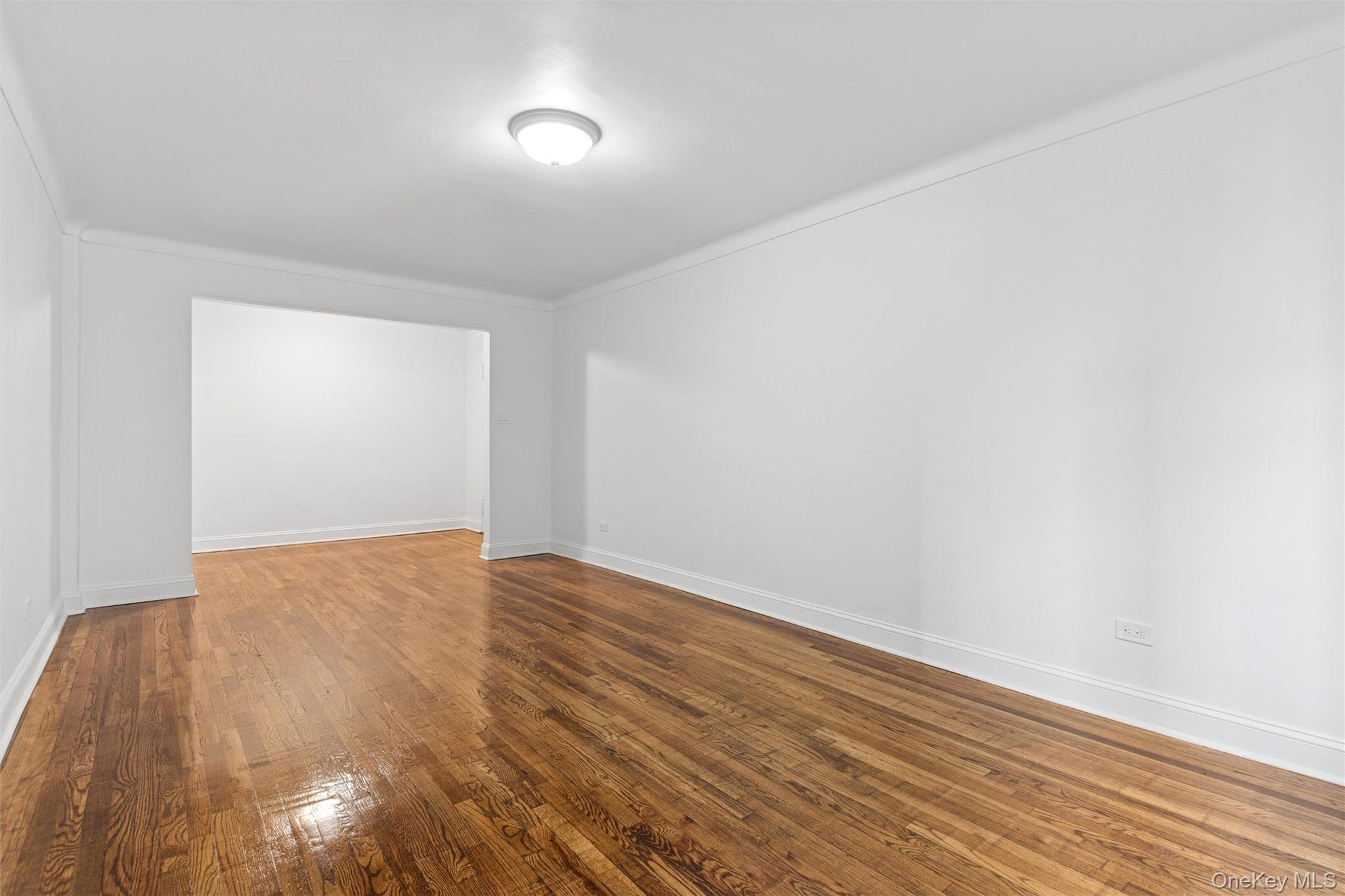 67-12 Yellowstone Boulevard, Unit B16 Queens, NY 11375 - Photo 7 of 15 Unfurnished room with hardwood / wood-style flooring and ornamental molding