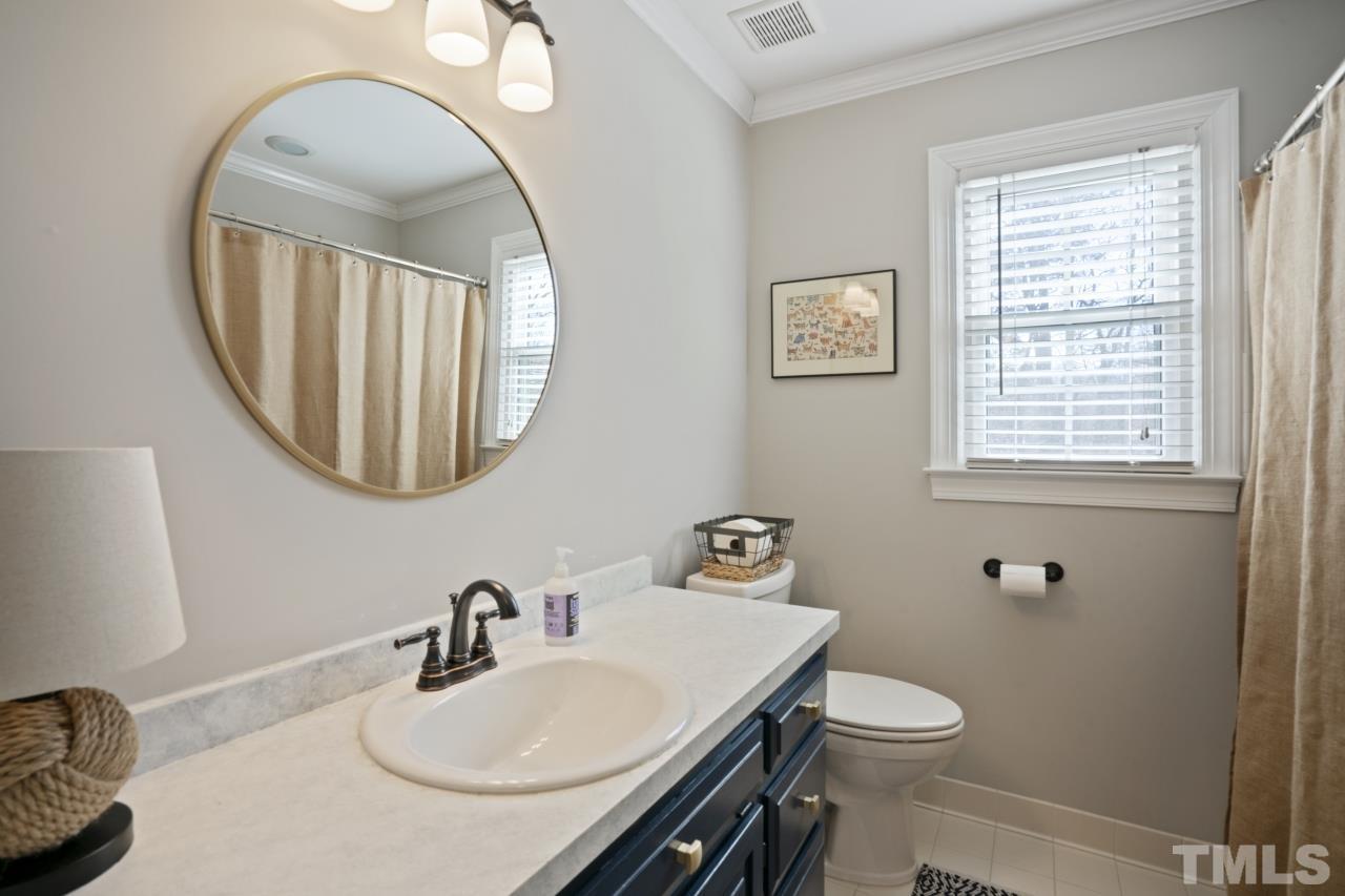 2209 Middlefield Court Raleigh, NC 27615 - Photo 16 of 25 a bathroom with a sink a toilet and a mirror