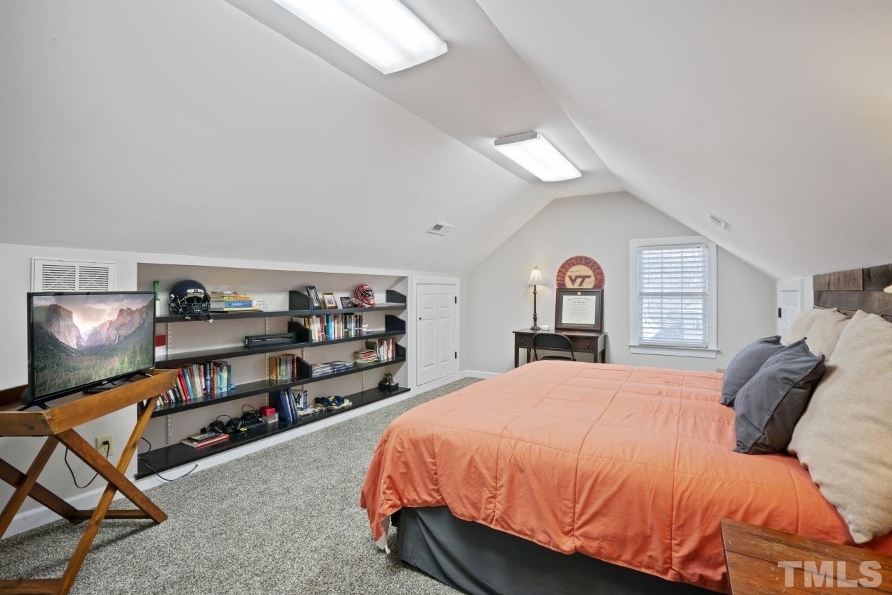 2209 Middlefield Court Raleigh, NC 27615 - Photo 22 of 25 a bedroom with a bed and a flat tv screen on the dresser