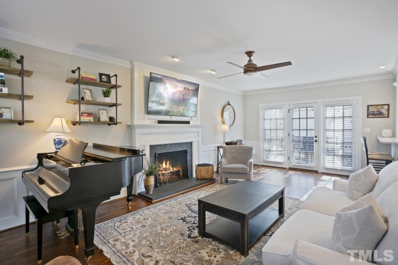 2209 Middlefield Court Raleigh, NC 27615 - Photo 7 of 25 a living room with furniture a flat screen tv and a fireplace