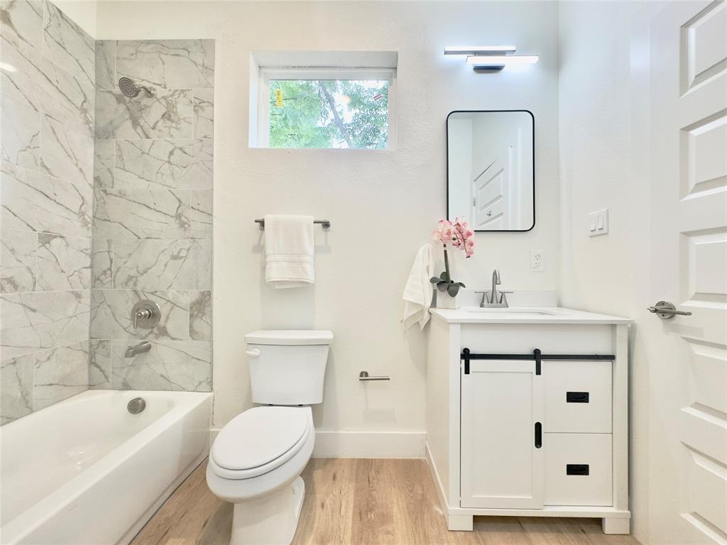 3801 Carpenter Avenue Dallas, TX 75210 - Photo 12 of 19 a bathroom with a sink a toilet and a mirror