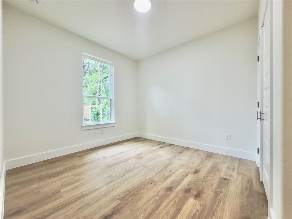 3801 Carpenter Avenue Dallas, TX 75210 - Photo 18 of 19 an empty room with wooden floor and windows