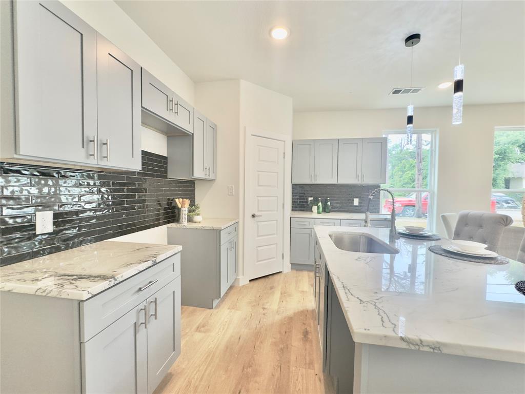 3801 Carpenter Avenue Dallas, TX 75210 - Photo 19 of 19 a kitchen with a sink a stove a refrigerator and white cabinets