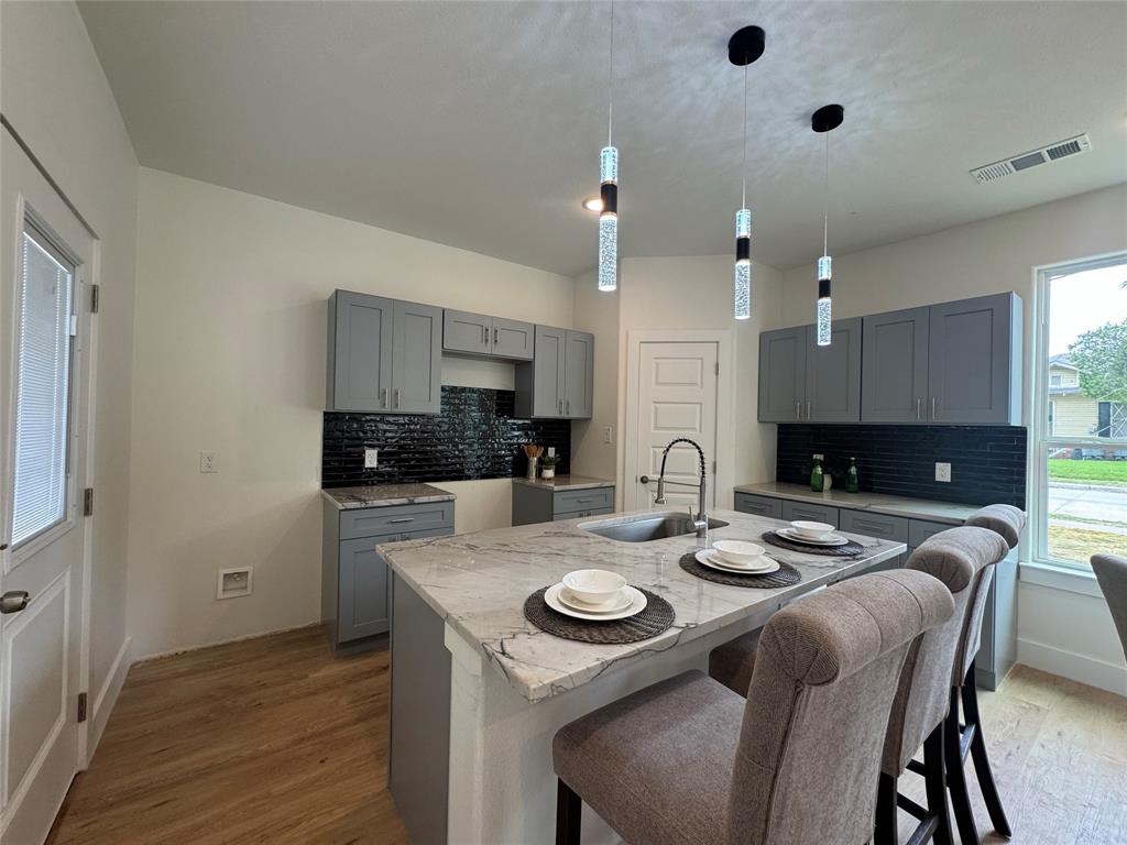3801 Carpenter Avenue Dallas, TX 75210 - Photo 5 of 19 a kitchen with a dining table chairs stainless steel appliances and cabinets