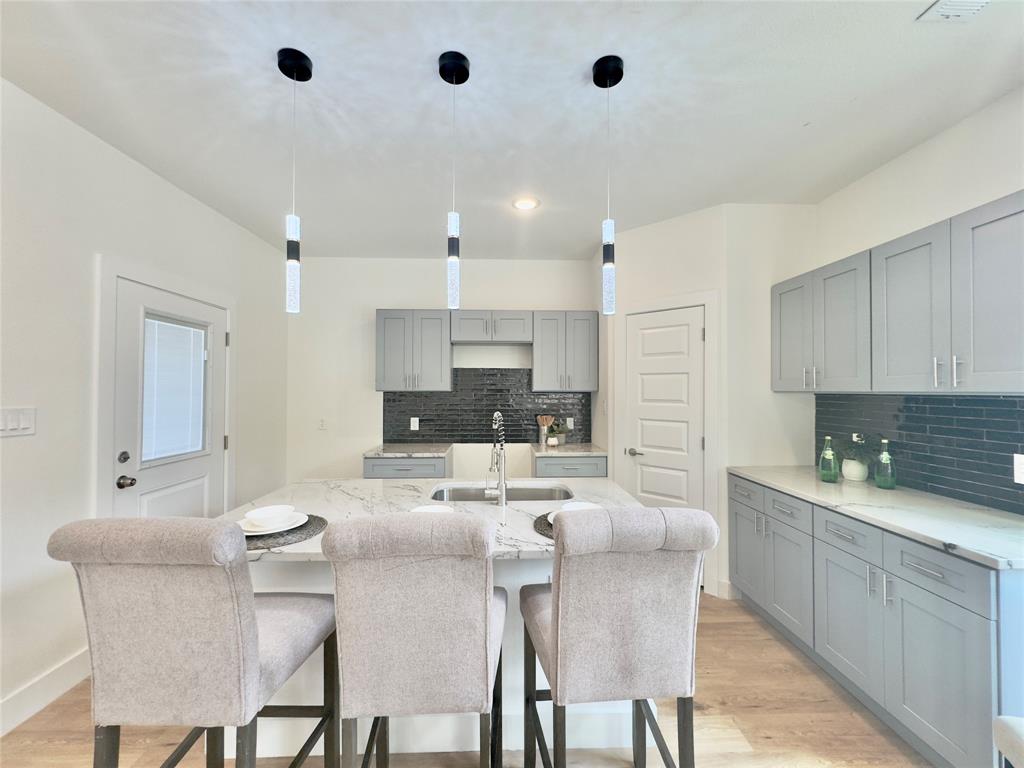 3801 Carpenter Avenue Dallas, TX 75210 - Photo 7 of 19 a kitchen with cabinets a sink stainless steel appliances and chairs