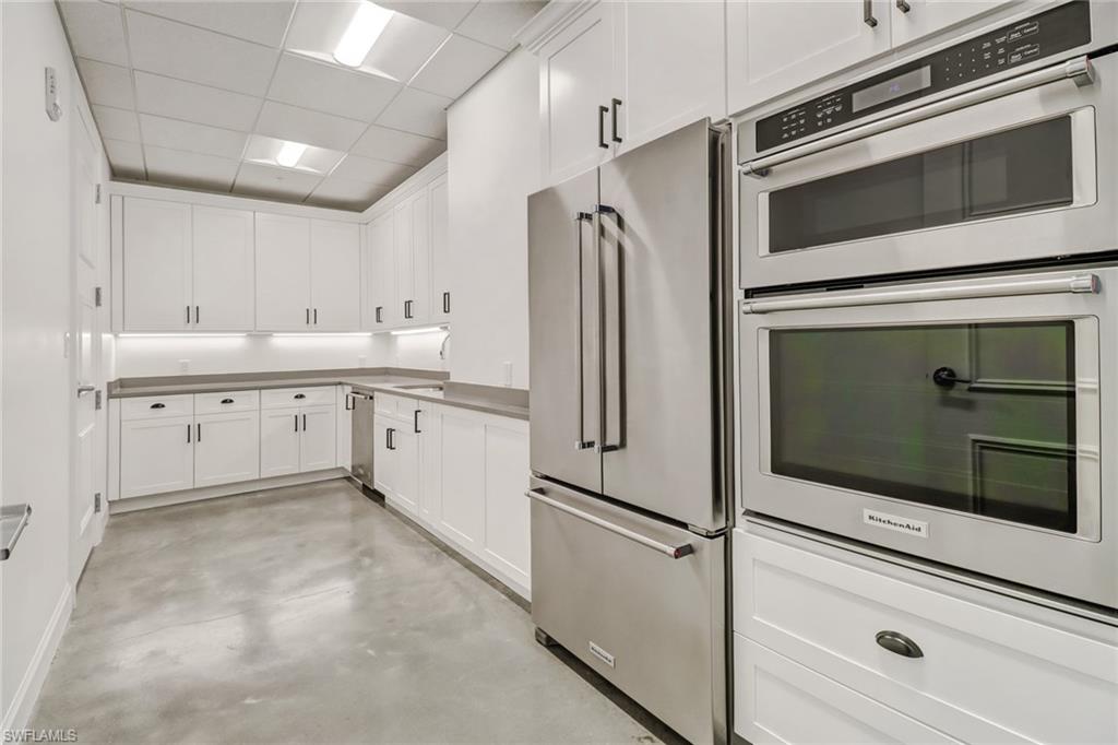 1115 Central Avenue, Unit 340 Naples, FL 34102 - Photo 21 of 39 a kitchen with stainless steel appliances white cabinets and a microwave oven