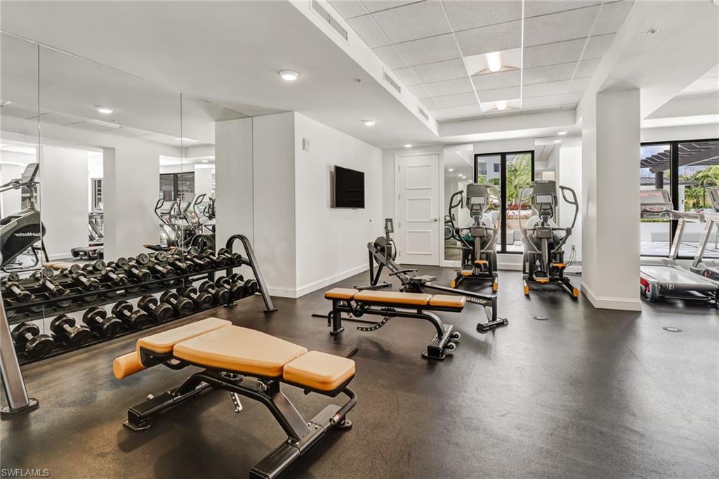 1115 Central Avenue, Unit 340 Naples, FL 34102 - Photo 35 of 39 a room with wooden floor and gym equipment
