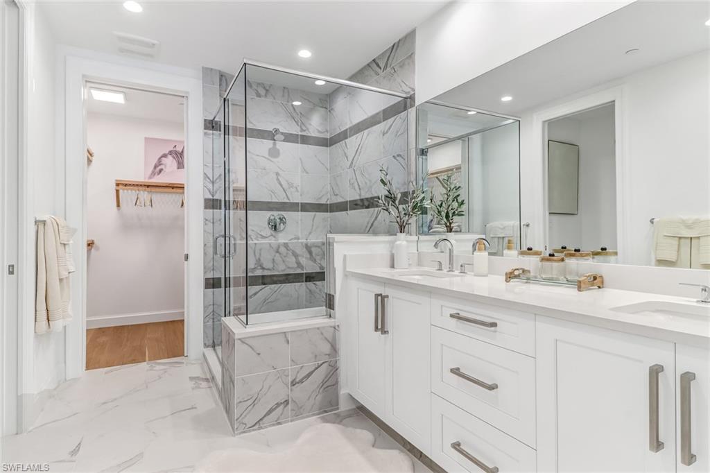 1115 Central Avenue, Unit 340 Naples, FL 34102 - Photo 38 of 39 a bathroom with a double vanity sink mirror and shower