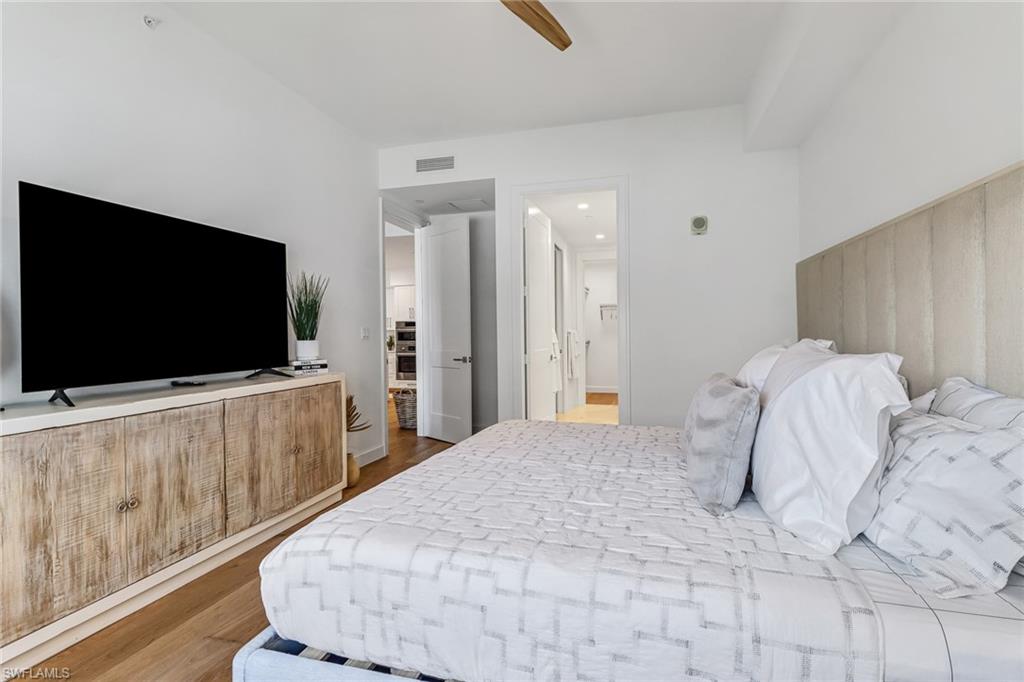 1115 Central Avenue, Unit 340 Naples, FL 34102 - Photo 8 of 39 a bedroom with a flat screen tv and a bed